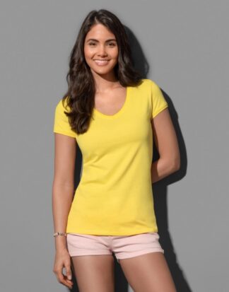 Μια γυναίκα που φοράει μια κοντομάνικη κίτρινη μπλούζα με λαιμόκοψη V και σορτσάκι