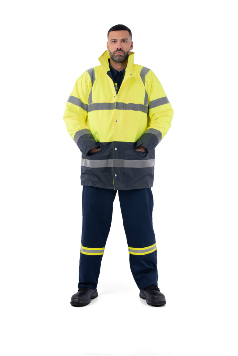 άνδρας που φοράει ανακλαστικό μπουφάν εργασίας σε χρώματα κίτρινο και μπλε με τσέπες και κουμπιά και παντελόνι ανακλαστικό ίδιων χρωμάτων