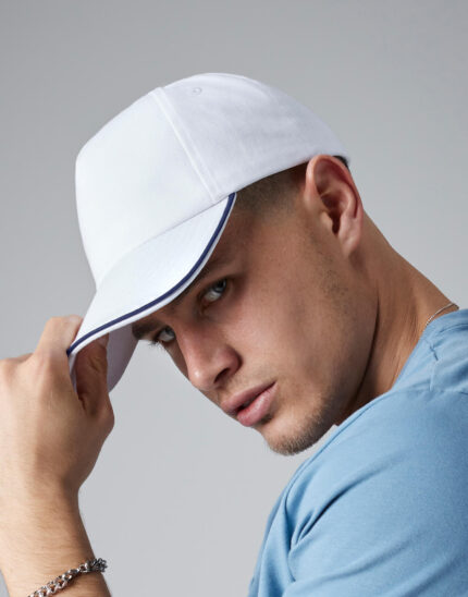άνδρας που φοράει unisex καπέλο τζόκει ενηλίκων σε χρώμα λευκό και στο γείσο έχει μια γραμμή σκούρα μπλε